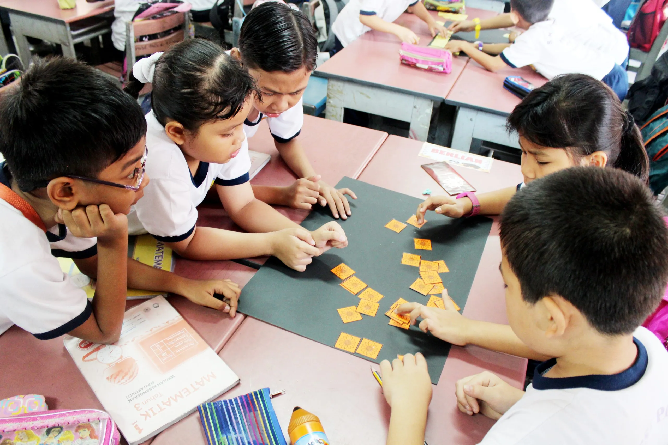 Primary school pupils working with letter cards at a table